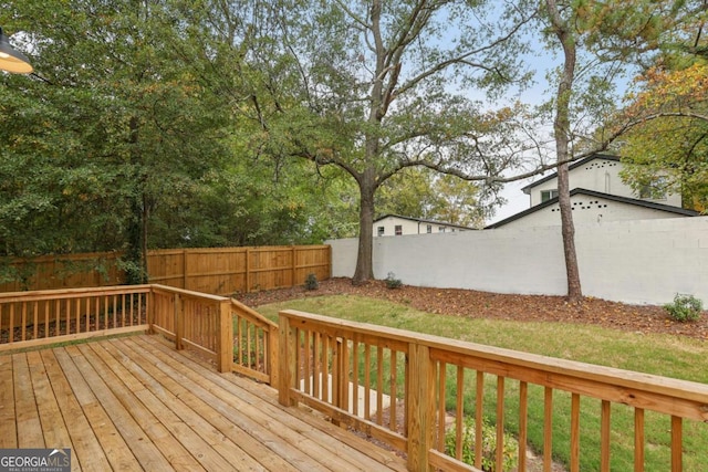 deck featuring a lawn and a fenced backyard
