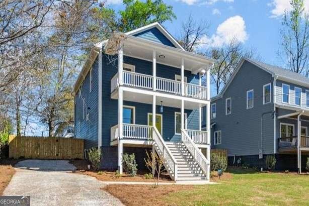 view of front of house featuring a porch, a balcony, stairway, and a front yard