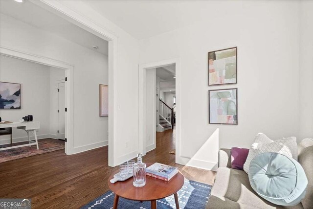 living room featuring stairway, baseboards, and wood finished floors