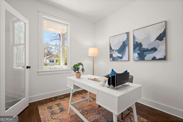 home office with visible vents, baseboards, and dark wood-type flooring