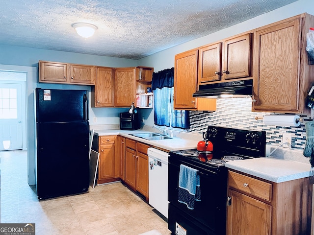 kitchen featuring tasteful backsplash, plenty of natural light, sink, and black appliances