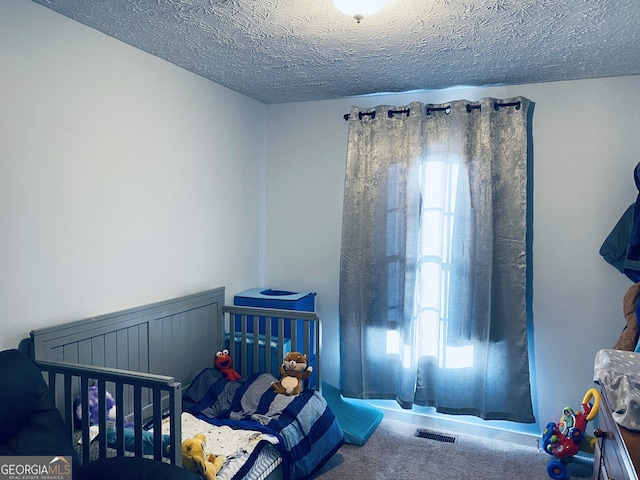 bedroom featuring carpet floors and a textured ceiling