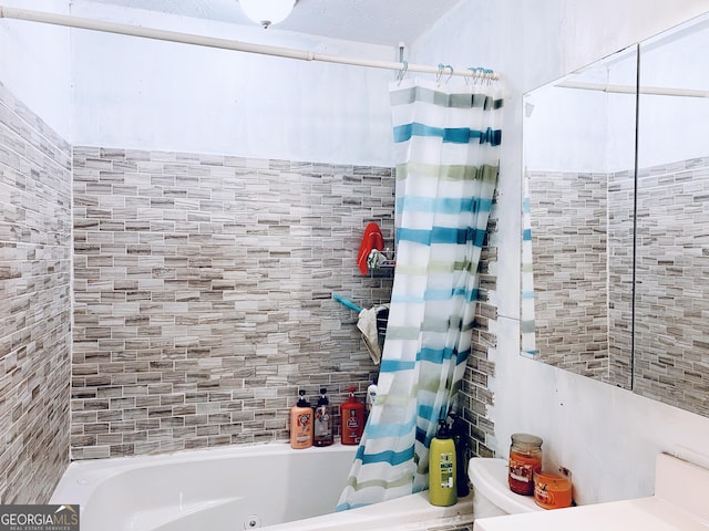 bathroom with shower / bathtub combination with curtain and toilet