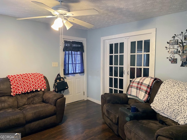 living room featuring french doors, ceiling fan, dark hardwood / wood-style flooring, and a textured ceiling