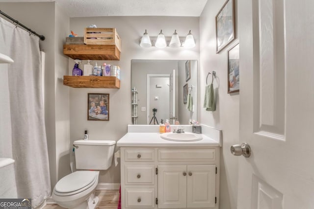 bathroom featuring vanity, a textured ceiling, and toilet