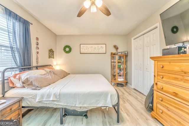 bedroom with ceiling fan, light hardwood / wood-style floors, and a closet