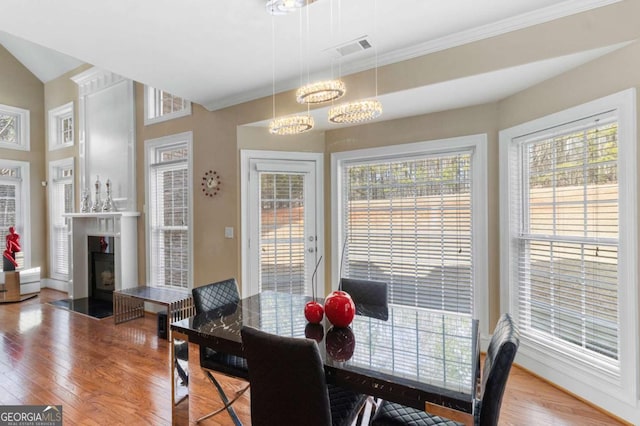 dining room with crown molding, wood-type flooring, and a chandelier