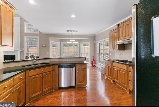 kitchen featuring sink, dark wood-type flooring, stainless steel appliances, and kitchen peninsula