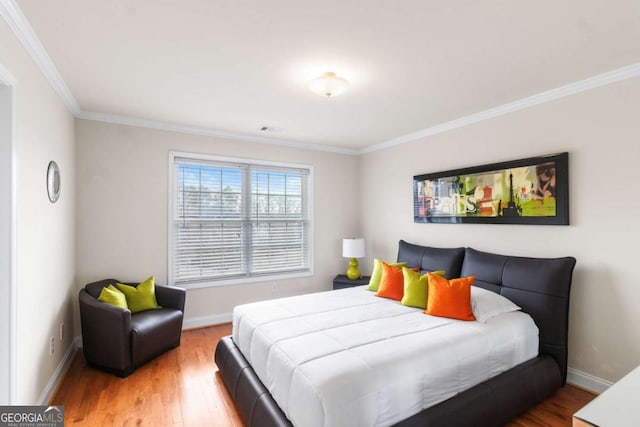 bedroom with hardwood / wood-style flooring and crown molding