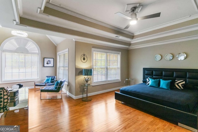 bedroom featuring a tray ceiling, ornamental molding, and hardwood / wood-style flooring