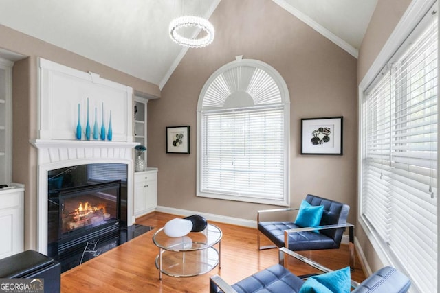 living room with hardwood / wood-style flooring, built in shelves, and vaulted ceiling