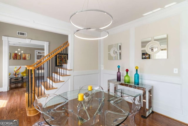 dining space with ornamental molding and hardwood / wood-style floors