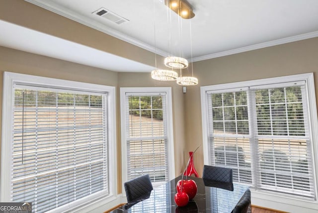 dining room with ornamental molding and a notable chandelier