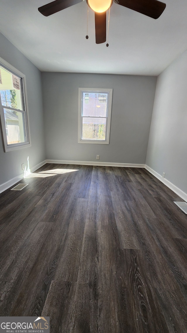 spare room with dark wood-type flooring and ceiling fan