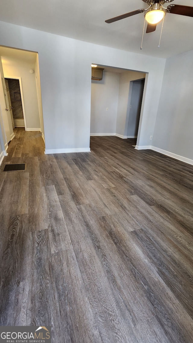 unfurnished room featuring dark hardwood / wood-style floors and ceiling fan