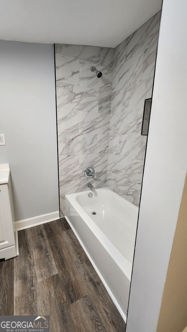 bathroom with vanity, tiled shower / bath combo, and wood-type flooring