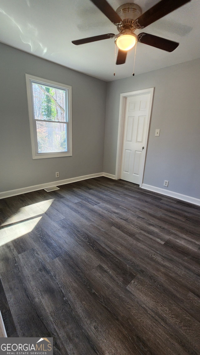 unfurnished room featuring dark hardwood / wood-style floors and ceiling fan