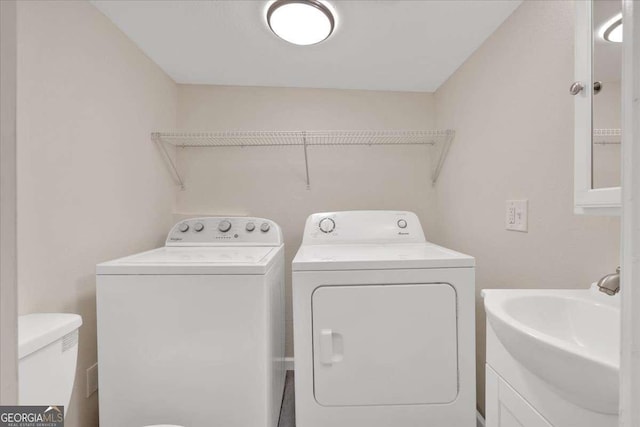 laundry room with laundry area, a sink, and washer and clothes dryer
