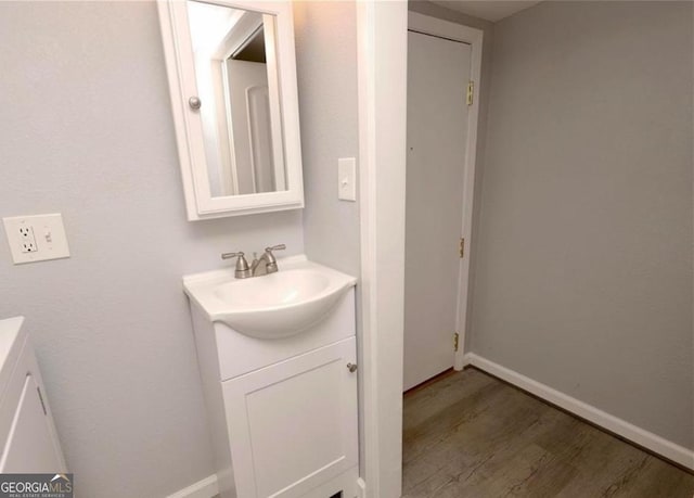 bathroom with baseboards, vanity, and wood finished floors
