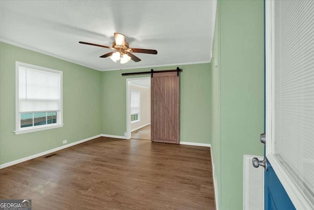 unfurnished room featuring baseboards, crown molding, ceiling fan, and dark wood-type flooring