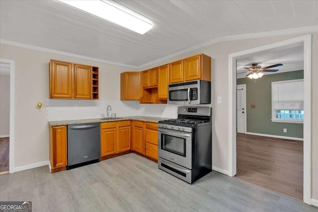 kitchen with light wood finished floors, a sink, open shelves, crown molding, and appliances with stainless steel finishes