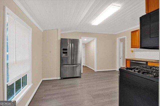 kitchen with light wood-style floors, gas stove, crown molding, and stainless steel refrigerator with ice dispenser