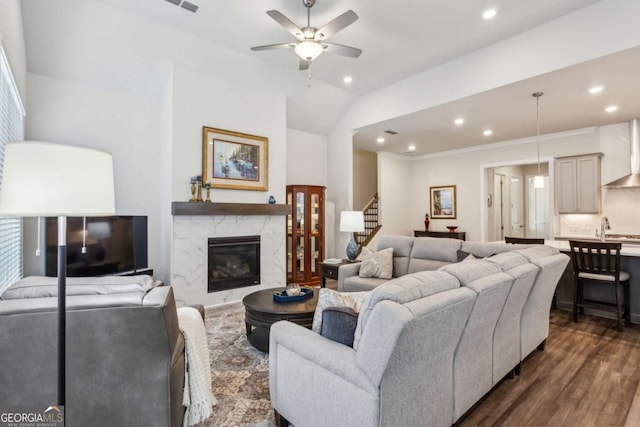 living room with ceiling fan, a fireplace, dark hardwood / wood-style floors, and vaulted ceiling