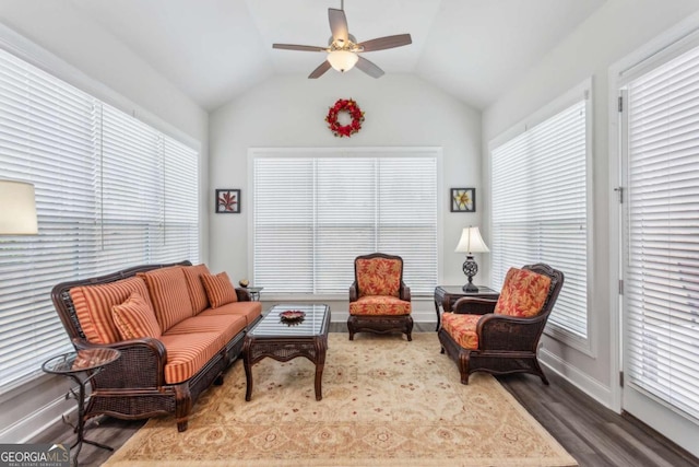 living area with ceiling fan, lofted ceiling, dark hardwood / wood-style floors, and a wealth of natural light