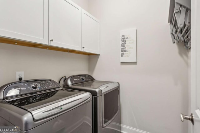 washroom featuring washing machine and dryer and cabinets