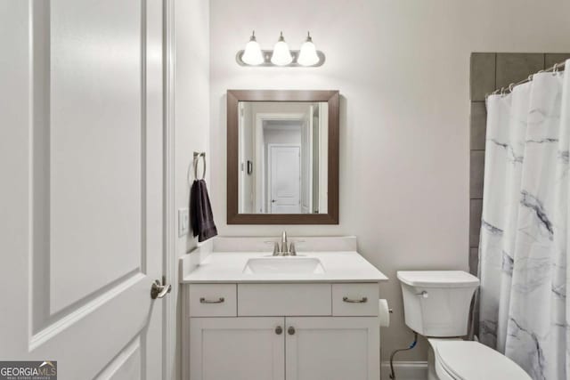 bathroom featuring vanity, curtained shower, and toilet