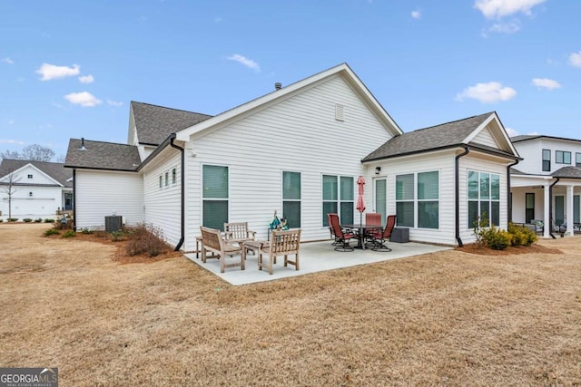 rear view of house featuring a yard, central AC, and a patio