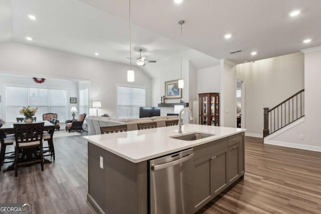 kitchen with lofted ceiling, sink, hanging light fixtures, a center island with sink, and stainless steel dishwasher