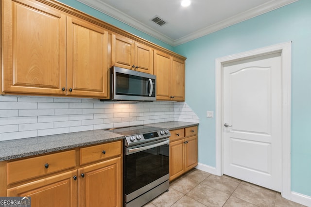 17 Coastal Walk, Saint Marys, GA 31558 - kitchen with tasteful backsplash, dark stone counters, light tile patterned floors, stainless steel appliances, and crown molding