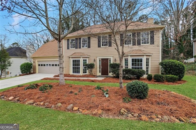 colonial-style house featuring a garage and a front lawn