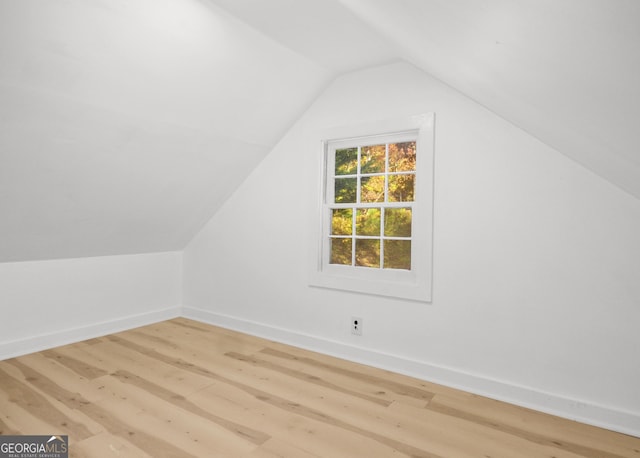 additional living space featuring lofted ceiling and hardwood / wood-style floors