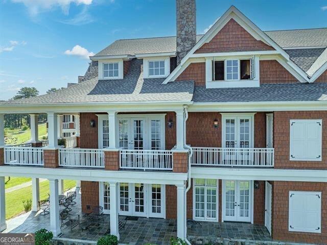 view of front facade with a patio, french doors, and a balcony