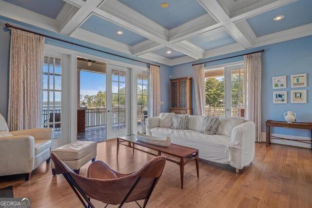 living room with french doors, coffered ceiling, light hardwood / wood-style flooring, and beamed ceiling