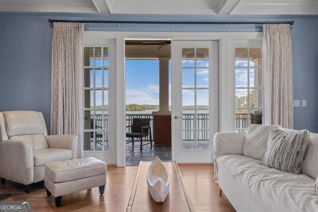 living room featuring crown molding, hardwood / wood-style floors, beam ceiling, and coffered ceiling