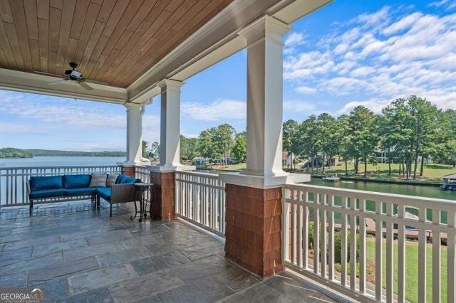 view of patio with ceiling fan and a water view