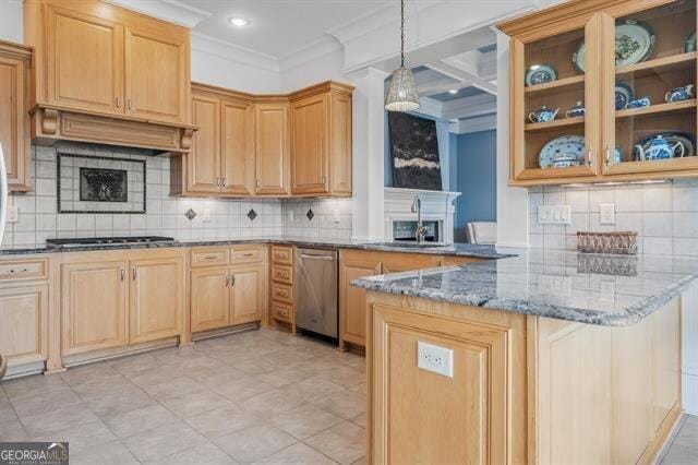 kitchen with appliances with stainless steel finishes, sink, dark stone countertops, hanging light fixtures, and kitchen peninsula