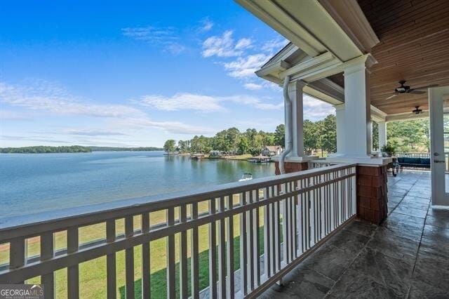 balcony featuring a water view and ceiling fan