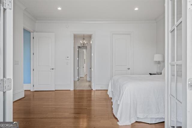 bedroom featuring crown molding and hardwood / wood-style flooring