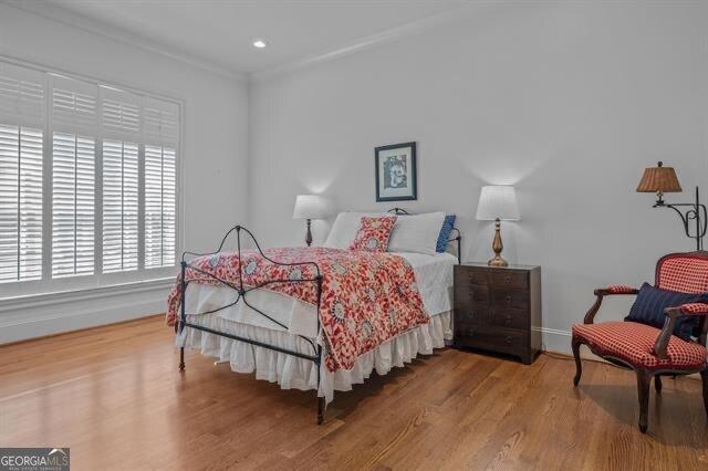 bedroom with crown molding and hardwood / wood-style floors