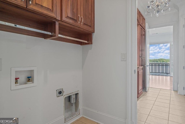 clothes washing area with cabinets, a chandelier, light tile patterned floors, washer hookup, and hookup for an electric dryer