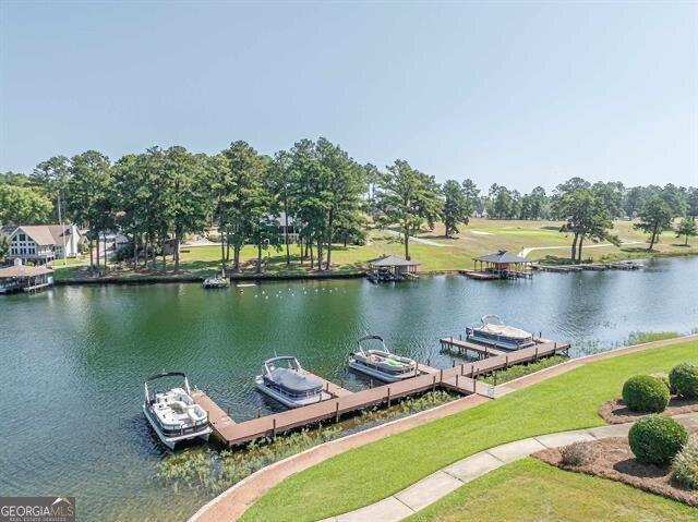 dock area with a water view and a lawn