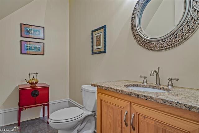 bathroom featuring tile patterned floors, vanity, and toilet