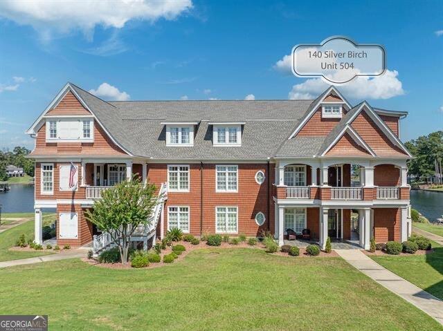 view of front of home with a water view and a front lawn