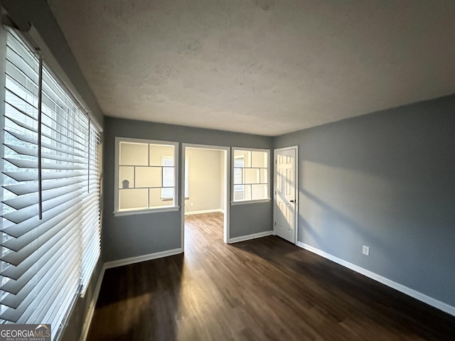 unfurnished room featuring dark wood-type flooring