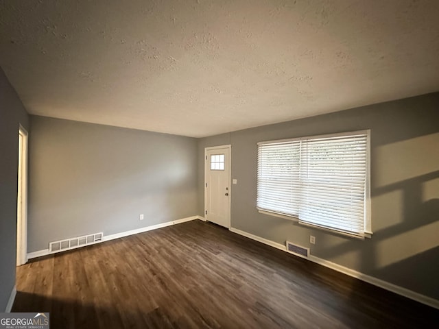 foyer entrance featuring dark wood-type flooring and a textured ceiling