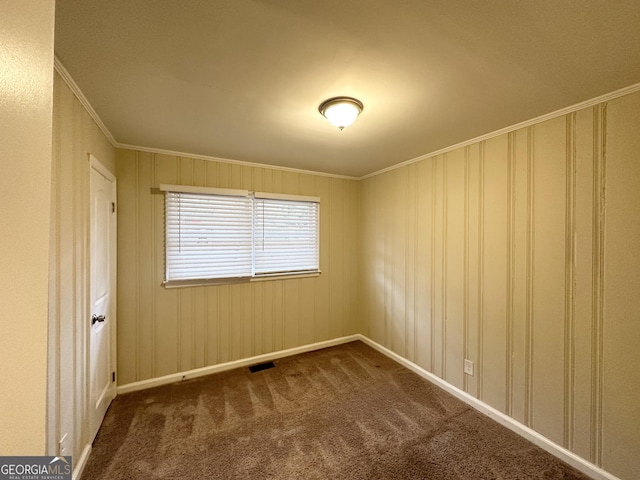 spare room with dark colored carpet and ornamental molding